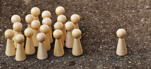 Board game pieces, one leading a group of them. Photo.