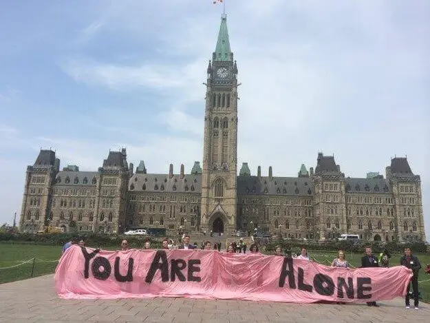 Sign "You are not alone" but the word "not" is low contrast.