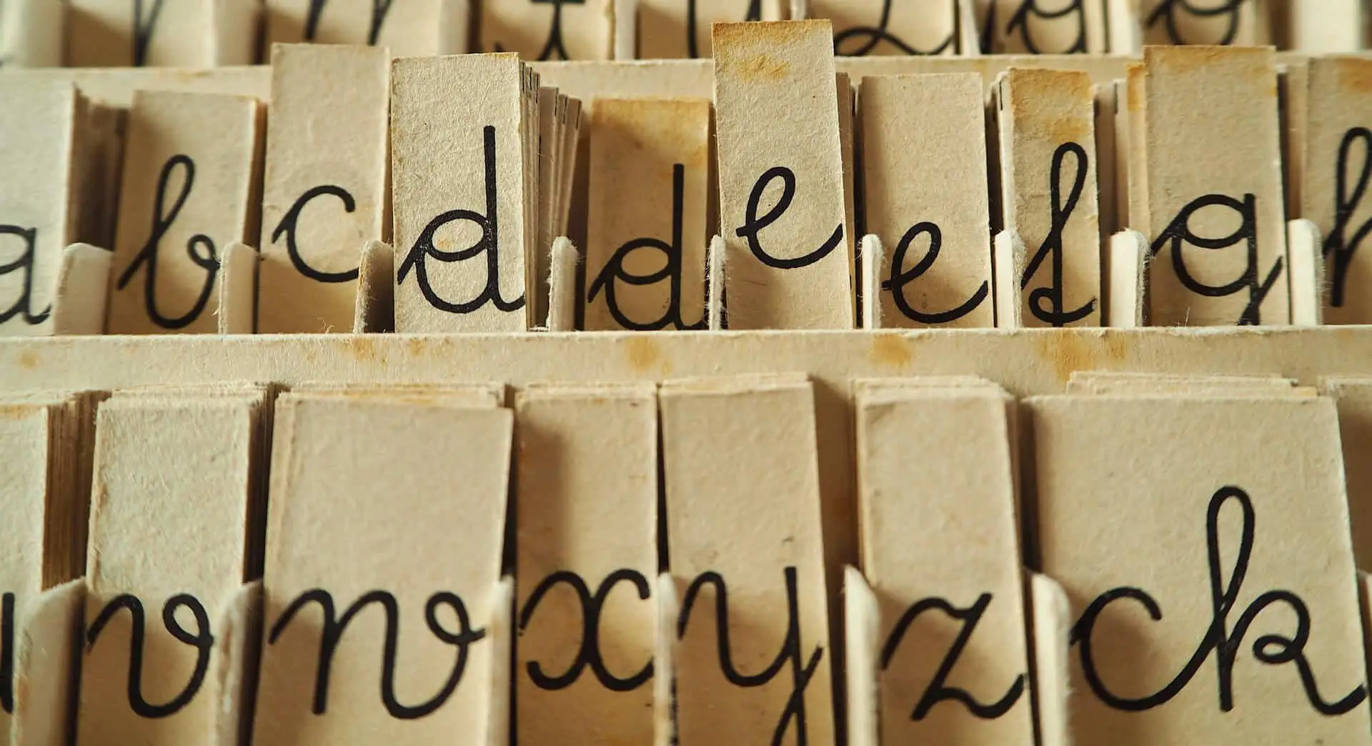 Letters of alphabet written on old paper with handwriting. Photo.