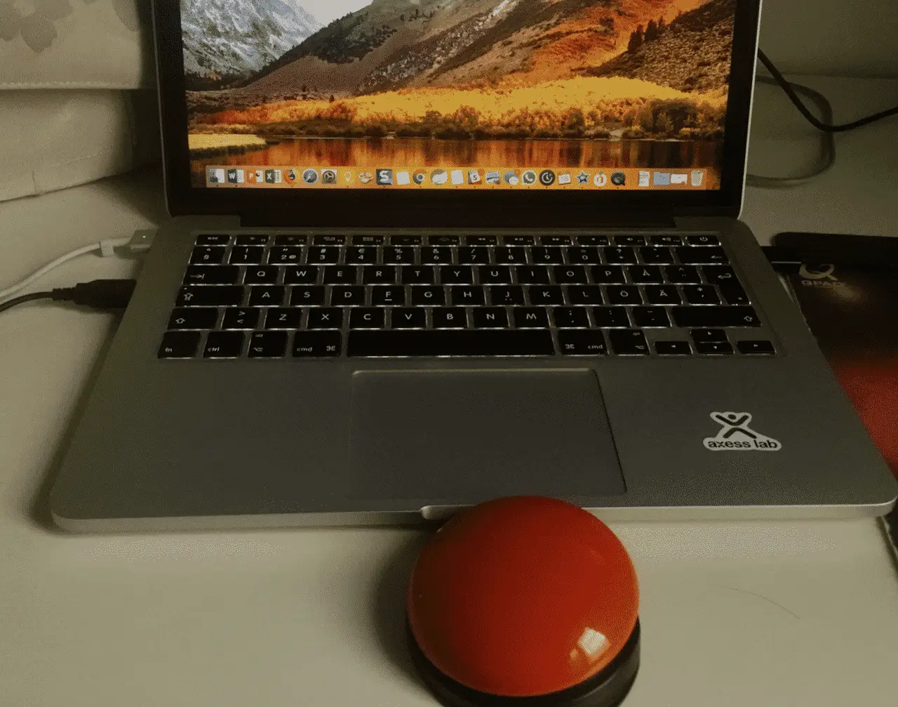 Red switch by a macbook. About the size of the computer's trackpad.