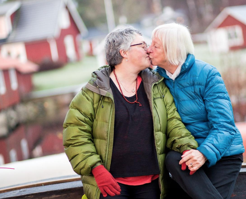 Two older women kissing.