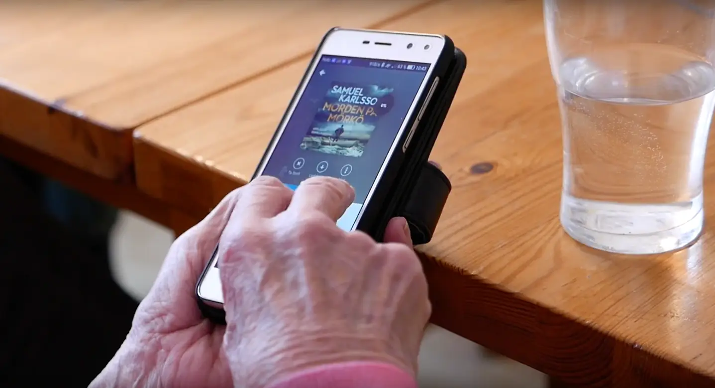 Elderly person using an app on a smartphone.