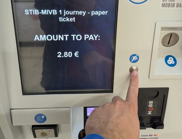 Ticket machine, with finger pressing support button.
